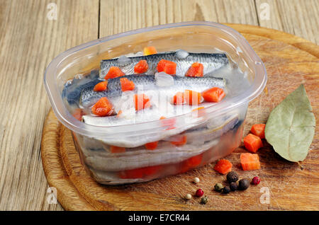 Gesalzener Fisch mit Karotten in geöffneten Glas Küche Bord mariniert Stockfoto