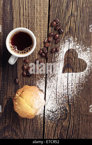 Tasse Kaffee und Kuchen auf Vintage Holz-Hintergrund mit Herz Stockfoto