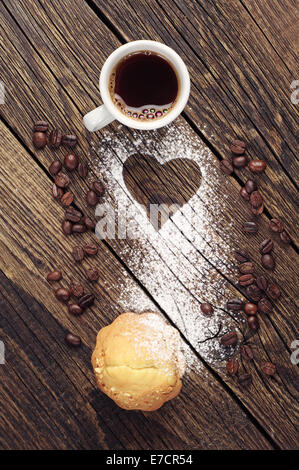 Kuchen und eine Tasse Kaffee auf Vintage Holz-Hintergrund mit Herz Stockfoto