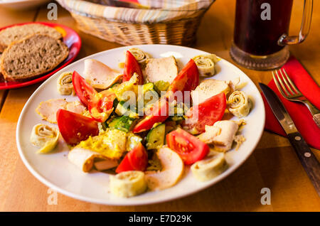 Hähnchen-Salat mit Knoblauch, Tomaten und Eiern. Stockfoto