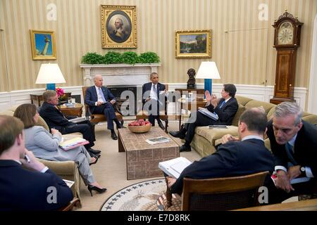 US-Präsident Barack Obama und Vize-Präsident Joe Biden erhalten die Presidential Daily Briefing als Chef des Stabes Denis McDonough, rechts, mit Ben Rhodes, stellvertretender nationaler Sicherheitsberater für strategische Kommunikation im Oval Office des weißen Hauses 18. Juli 2014 in Washington, DC verleiht. Stockfoto