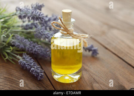 Ätherisches Lavendelöl mit frischen Blumen auf hölzernen Hintergrund closeup Stockfoto