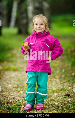 Glückliches kleines Mädchen mit einem Pilz Stockfoto