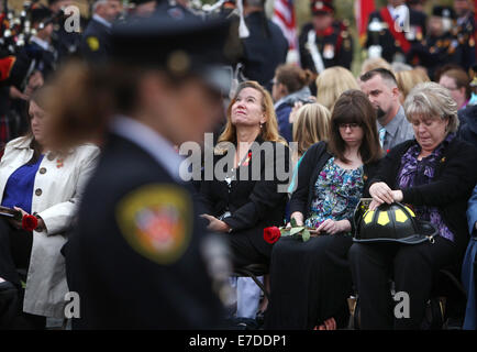 Ottawa, Kanada. 14. Sep, 2014. Familienmitglieder wehren Tränen bei der Canadian Firefighter Memorial in Ottawa, Kanada, am 14. September 2014. Die jährliche Veranstaltung zieht Hunderte von Feuerwehrleuten aus über dem Land zu Ehren ihrer gefallenen Kollegen und ihre Namen hinzugefügt, um zu sehen das jetzt 1200, die das Denkmal zu schmücken. Bildnachweis: Cole Burston/Xinhua/Alamy Live-Nachrichten Stockfoto