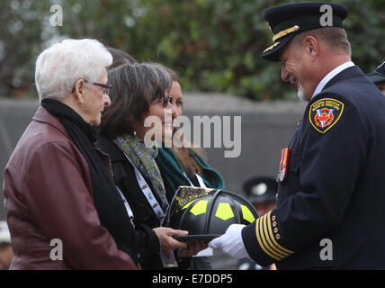 Ottawa, Kanada. 14. Sep, 2014. Edith Burch, ist Frau des späten Toronto Firefighter Randy Burch mit einem zeremoniellen Denkmal Helm an die Canadian Firefighter Memorial in Ottawa, Kanada, am 14. September 2014 vorgestellt. Die jährliche Veranstaltung zieht Hunderte von Feuerwehrleuten aus über dem Land zu Ehren ihrer gefallenen Kollegen und ihre Namen hinzugefügt, um zu sehen das jetzt 1200, die das Denkmal zu schmücken. Bildnachweis: Cole Burston/Xinhua/Alamy Live-Nachrichten Stockfoto