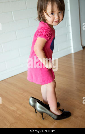 Babymädchen in ihrer Mutter Schuhe Stockfoto