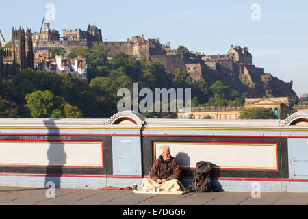 Obdachloser Betteln auf der Nordbrücke mit Edinburgh Castle im Hintergrund, Edinburgh, Scotland, UK Stockfoto