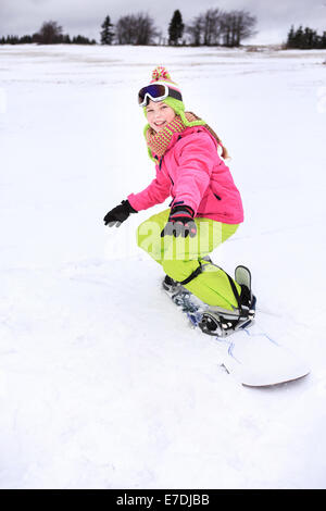 ein junges Mädchen, Snowboarden in den Alpen. Stockfoto