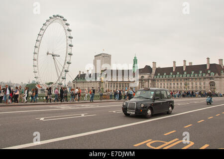 Londoner Black Taxi durchquert Westminster Bridge, London Eye und Sea Life Hintergrund Stockfoto