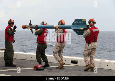 US Navy Ordnance Marines laden eine AIM-9 Gefangene Luft Training-Rakete auf einen Kampfhubschrauber AH-1Z Super Cobra im Flugbetrieb an Bord der USS San Diego 9. September 2014 in den Pazifischen Ozean tätig. Stockfoto