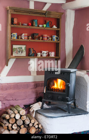 Ein traditionelles englisches Cottage Interieur, mit einem Holzofen im Wohnzimmer installiert (UK) Stockfoto