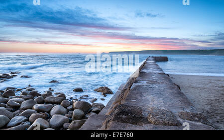 Wellen, die über die Hafenmauer Sennen Cove in der Nähe von Lands End in Cornwall Stockfoto