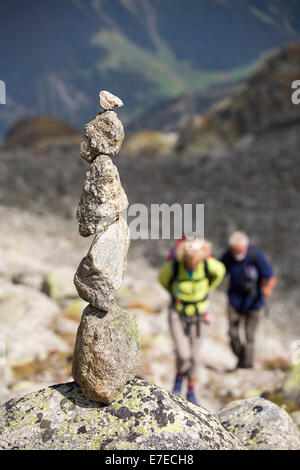 Wanderer machen die Tour du Mont Blanc aufsteigen in Richtung Cabanne D'Orny über dem Val Ferret in den Schweizer Alpen, mit einem Stein heruntergespült Stockfoto