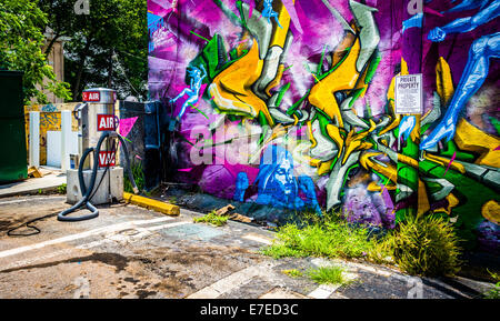 Graffiti auf eine Mauer und eine Luftpumpe an einer Tankstelle in kleinen fünf Punkte, Atlanta, Georgia. Stockfoto