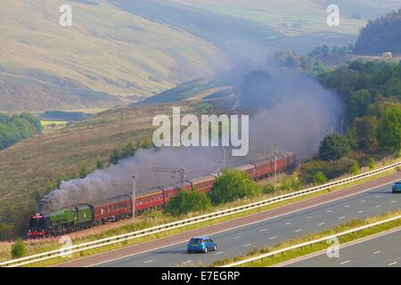 Zug Dampflok auf der Autobahn M6 im Tal Flusses Lune. Howgills, Cumbria, West Coast Main Line, England, Vereinigtes Königreich. Stockfoto