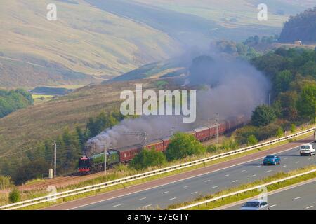 Zug Dampflok auf der Autobahn M6 im Tal Flusses Lune. Howgills, Cumbria, West Coast Main Line, England, Vereinigtes Königreich. Stockfoto