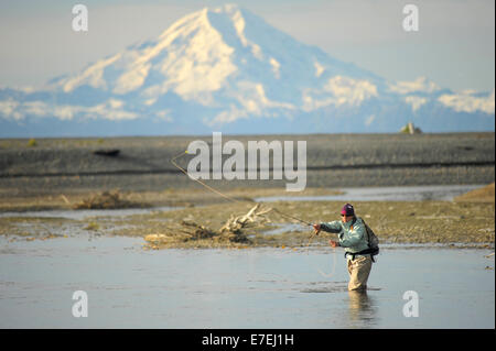 Frau wirft für wild Steelhead auf Deep Creek auf der westlichen Halbinsel Kenai, Alaska, September 2009.  Fließt in Cook Inlet nördlich von Homer, fallen die Gewässer des Deep Creek und der Anker Fluss Host spät läuft wild Steelhead.  Der aktive Vulkan Mount Redoubt im Hintergrund. Stockfoto