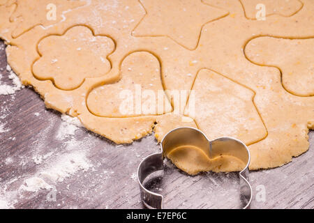 Weihnachten Lebkuchen aus ausgerollten Teig schneiden Stockfoto