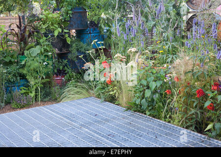 Garten Raum zu verbinden und zu wachsen - Blick auf Garten aus industriellen wiedergewonnen und wiederverwendet Upcycling Materialien Öltrommel Pflanzer UK Vertikale Gartenarbeit Stockfoto