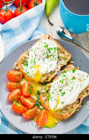 Sandwich mit pochiertem Ei und Cherry-Tomaten Stockfoto