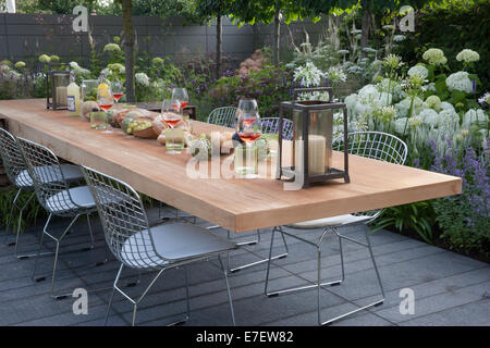 Gartenblick auf die Terrasse mit Gartenmöbeln, Tisch und Stühlen im Freien Wohnen Blumenränder Hydrangea Hydrangeas UK Hampton Court Flower Show Stockfoto