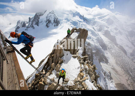Mont Blanc von der Aiguille Du Midi über Chamonix, Frankreich mit Bergsteiger auf der Cosmiques Arete, Klettern die Leiter für den Zugriff auf Stockfoto