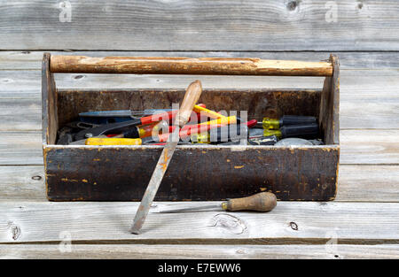 Horizontales Bild des alten Werkzeugkasten gefüllt mit Werkzeugen auf urigen Holzbrettern Stockfoto