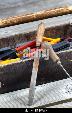 Vertikales Bild des alten Werkzeugkasten gefüllt mit Werkzeugen auf urigen Holzbrettern Stockfoto