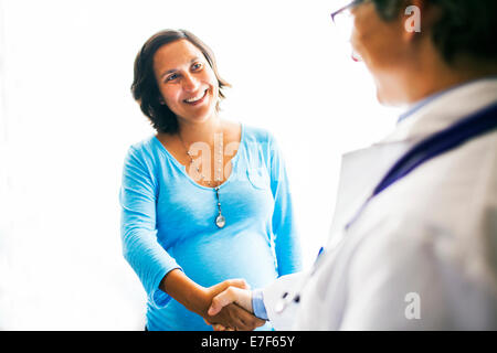 Schwangere Frau DoctorÕs Hand zu schütteln Stockfoto