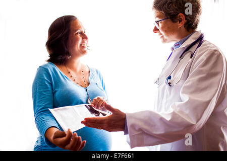 Arzt im Gespräch mit schwangeren Patientin Stockfoto