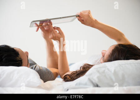 Paar mit Tablet-PC im Bett Stockfoto