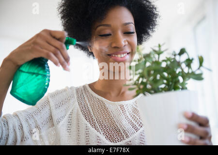 Afroamerikanische Frau Bewässerung Pflanzen Stockfoto