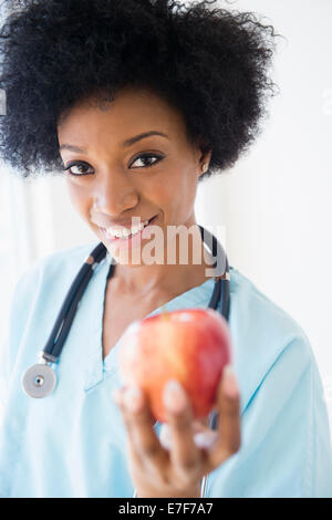 Afrikanische amerikanische Krankenschwester Holding Apfel Stockfoto