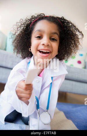 Afroamerikanische Mädchen spielen Arzt in Wohnzimmer Stockfoto