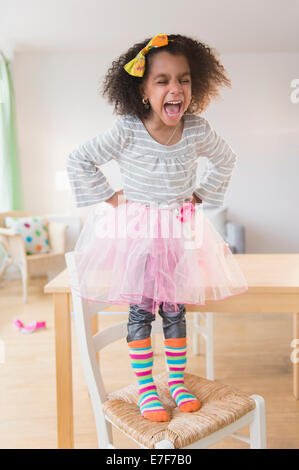 Afroamerikanische Mädchen schreien auf Stuhl Stockfoto