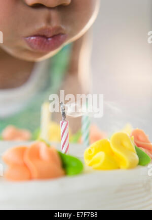 Afroamerikanische Mädchen bläst Kerzen auf Geburtstagskuchen Stockfoto