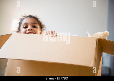 Afroamerikanische Mädchen spielen im Karton Stockfoto