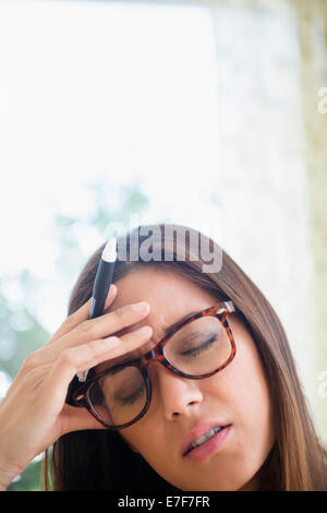 Frustrierte Frau reibt ihre Stirn Stockfoto