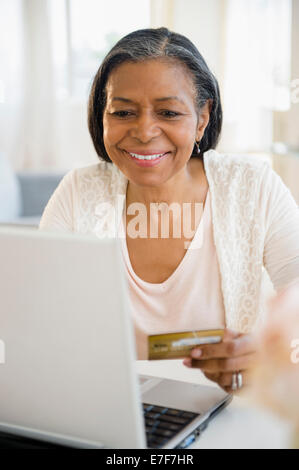 Gemischte Rassen Frau einkaufen auf laptop Stockfoto