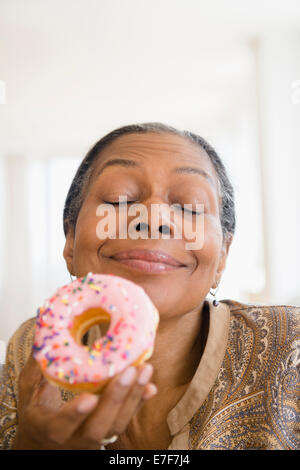 Gemischte Rassen Frau Essen donut Stockfoto