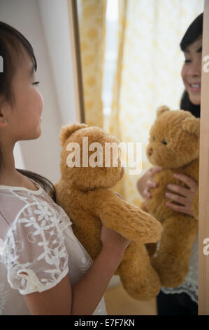 Philippinische Mädchen Teddybär im Spiegel zu bewundern Stockfoto