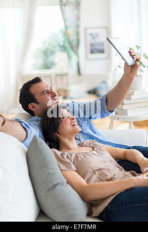 Hispanische paar mit Tablet-PC auf sofa Stockfoto