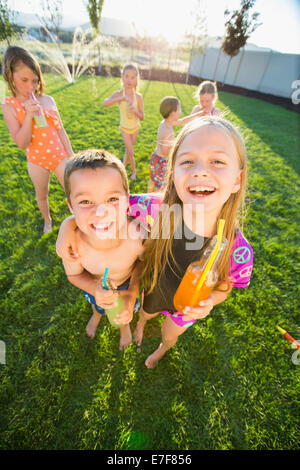 Kaukasische Kinder trinken Soda im Hinterhof Stockfoto