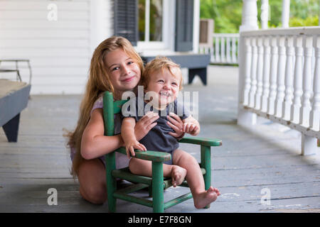 Kaukasische Mädchen und Kleinkind Bruder spielt auf Veranda Stockfoto