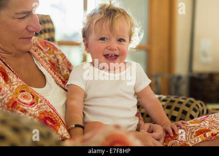 Kaukasische Mutter Holding Kleinkind im Wohnzimmer Stockfoto