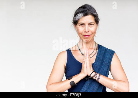 Ältere Hispanic Frau mit den Händen umklammert Stockfoto