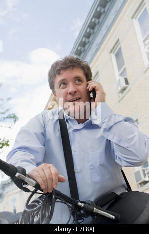 Hispano-Amerikaner Geschäftsmann reden über Handy auf dem Fahrrad Stadt Straße Stockfoto