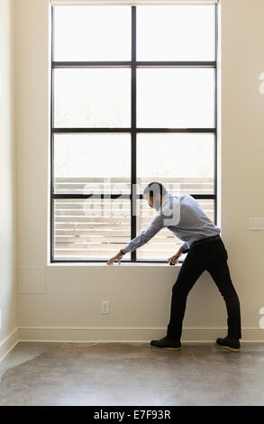 Gemischte Rassen Grundstücksmakler Messfenster im neuen Haus Stockfoto