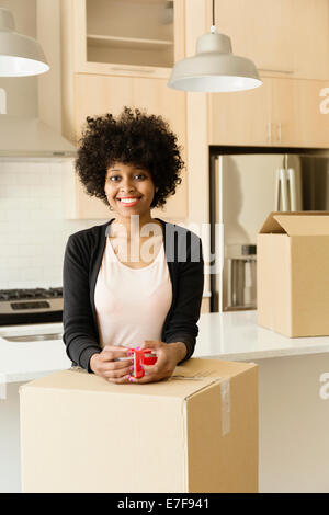 Gemischte Rassen Frau Kaffeetrinken im neuen Haus Stockfoto