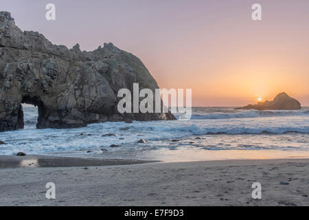 Wellen am felsigen Strand bei Sonnenuntergang Stockfoto